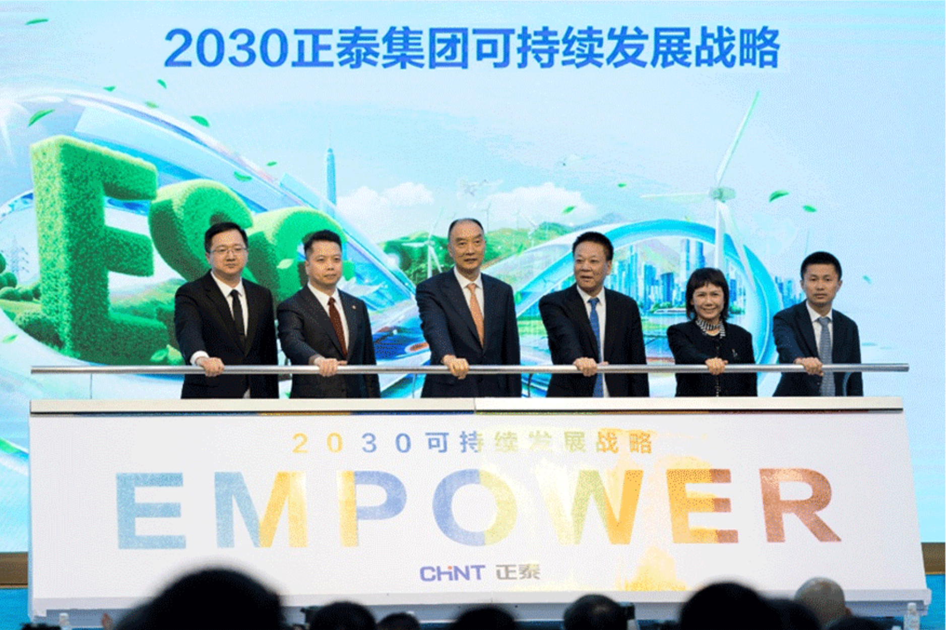CHINT Group executives at the launch ceremony of the 2030 Sustainable Development Strategy, standing before an ESG-themed backdrop with “EMPOWER” branding and green energy visuals.